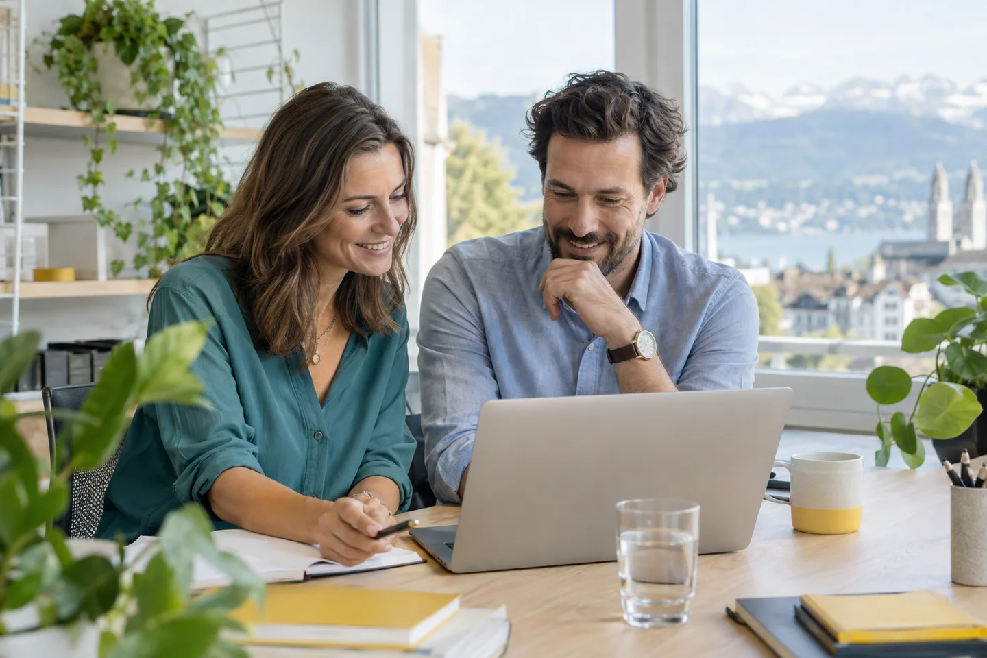 Zwei Personen arbeiten entspannt an einem Laptop in einem hellen Büro – KI-generiertes Symbolbild